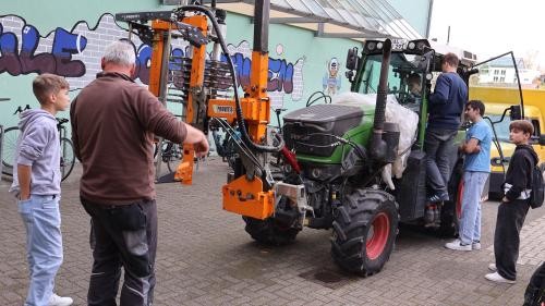 Foto zeigt Schüler bei der Begutachtung eines Traktors