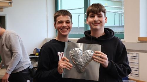 Foto zeigt Schüler mit Metallplatte in der Hand